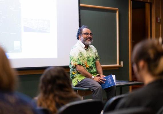 Ignacio Gallup-Diaz sitting on a table in a lecture hall